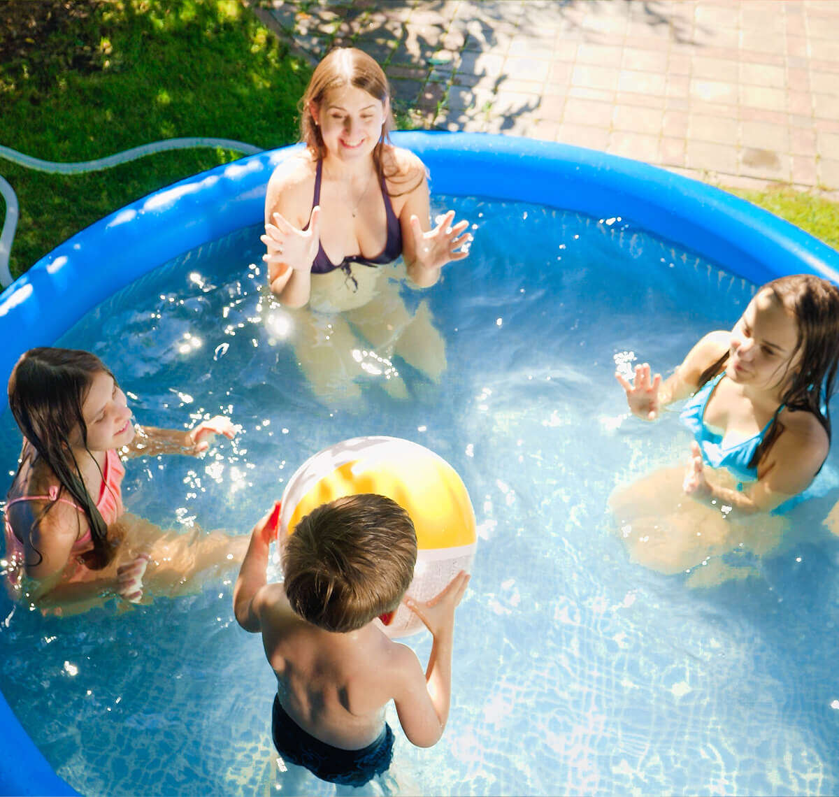 Familie spielen mit Ball im Pool 1200x1140