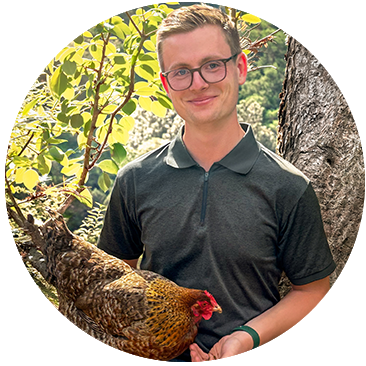 Lukas Sänn draußen mit Huhn im Arm